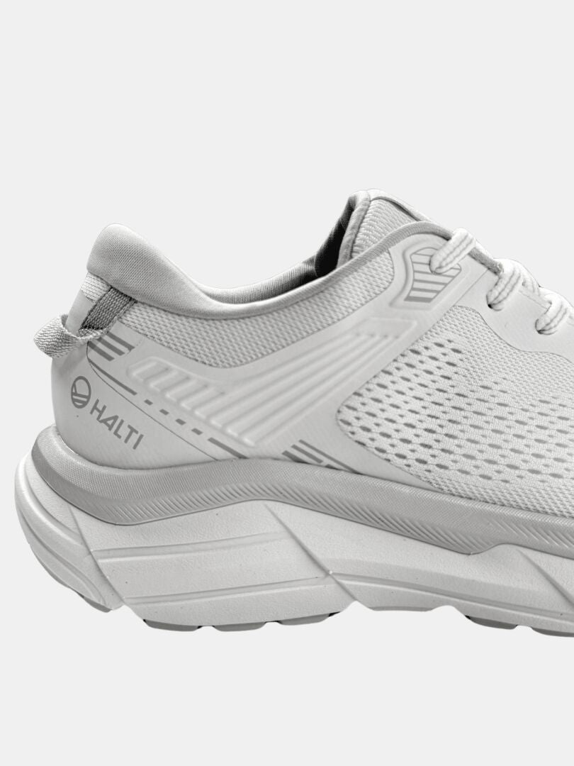 Sivukuva valkoisista Halti Tempo 3 Lenkkari Miesten -kengistä, joissa on paksu pohja ja verkkopäällinen ja jotka on suunniteltu mukavuutta varten kovilla pinnoilla.