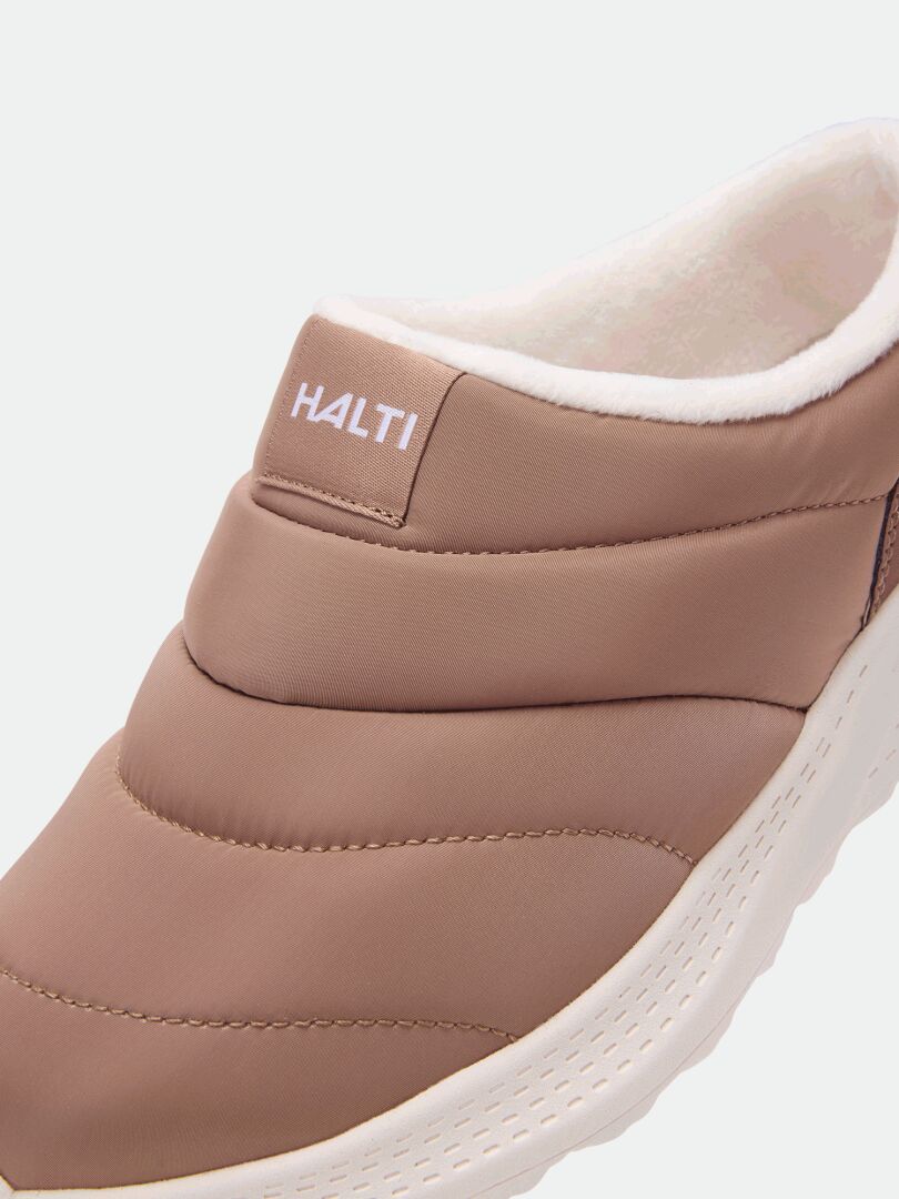 Lähikuva Halti Rest 2 Tohvelit -kengistä: ruskeat slip-on-kengät, joissa on muistivaahtopohjallinen ja Halti-logo kengän etuosassa.
