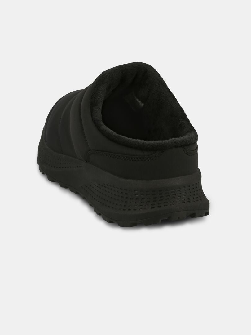 Halti Rest 2 -tossut: mustat slip-on-tossut, memoryfoam-pohjallinen, pehmeä sisäpuoli, kuvioitu pohja sisä- ja ulkokäyttöön.