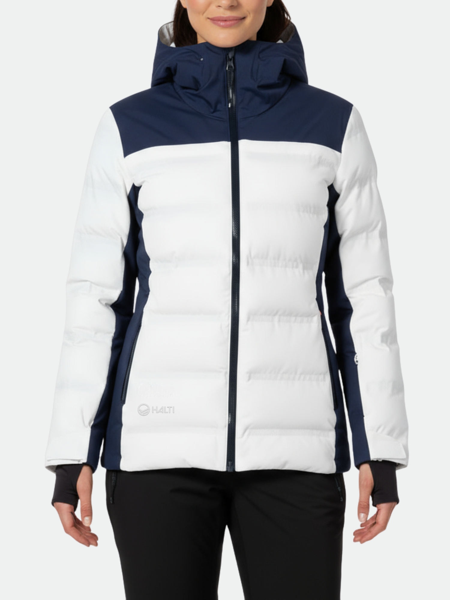 Nainen Halti Lis Naisten DrymaxX Laskettelutakki ja mustat housut, kasvot eteenpäin tavallista taustaa vasten.