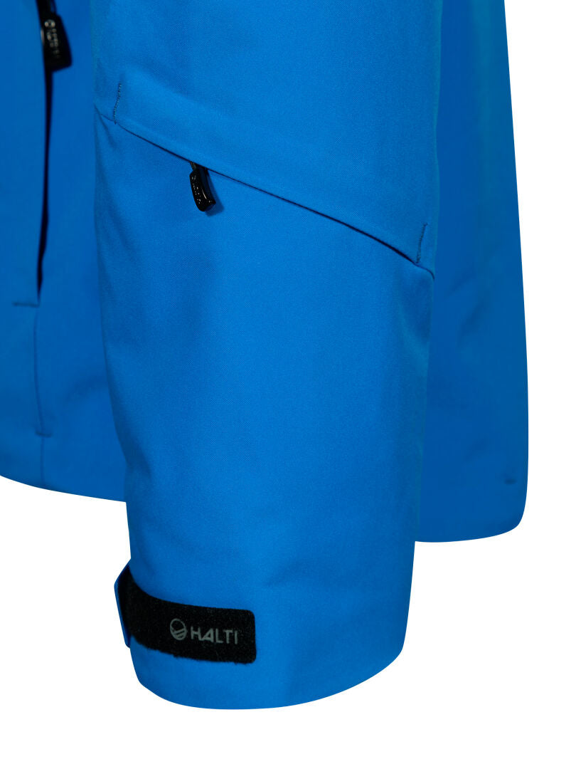 Lähikuva Vertica DX -miesten sinisen hiihtotakin hihasta, jossa on vetoketjutasku ja musta Halti-logo hihansuussa.