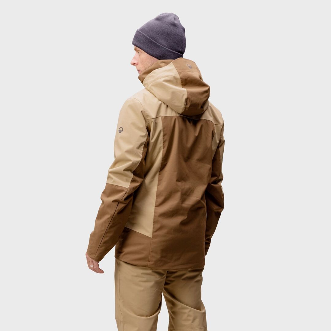 Halti Planker DX Laskettelutakki Miesten henkilö seisoo kasvot menosuuntaan, päällään harmaa pipo.