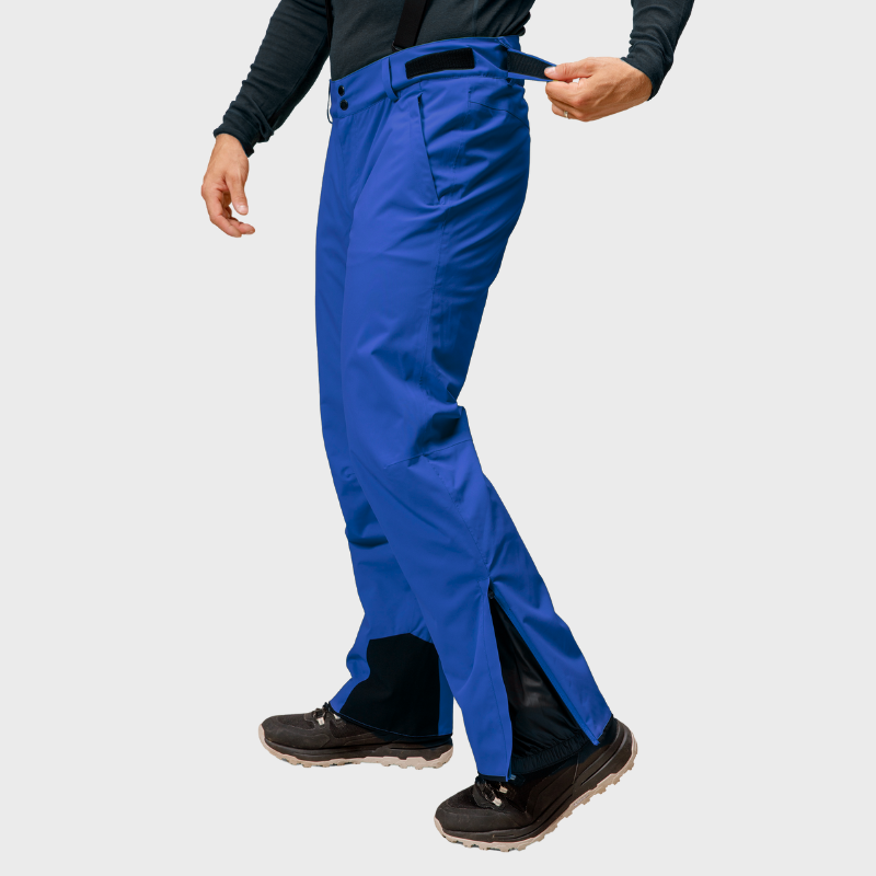 Henkilö säätää sinisten Halti Trusty DrymaxX Lasketteluhousut Miesten -kenkien vyötärönauhaa mustissa kengissä.