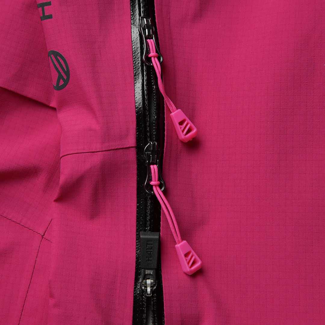 Lähikuva vaaleanpunaisesta takista, jossa on musta vetoketju - sopii täydellisesti Halti Alpine 3L DX Kuorihousut Naisten kanssa.