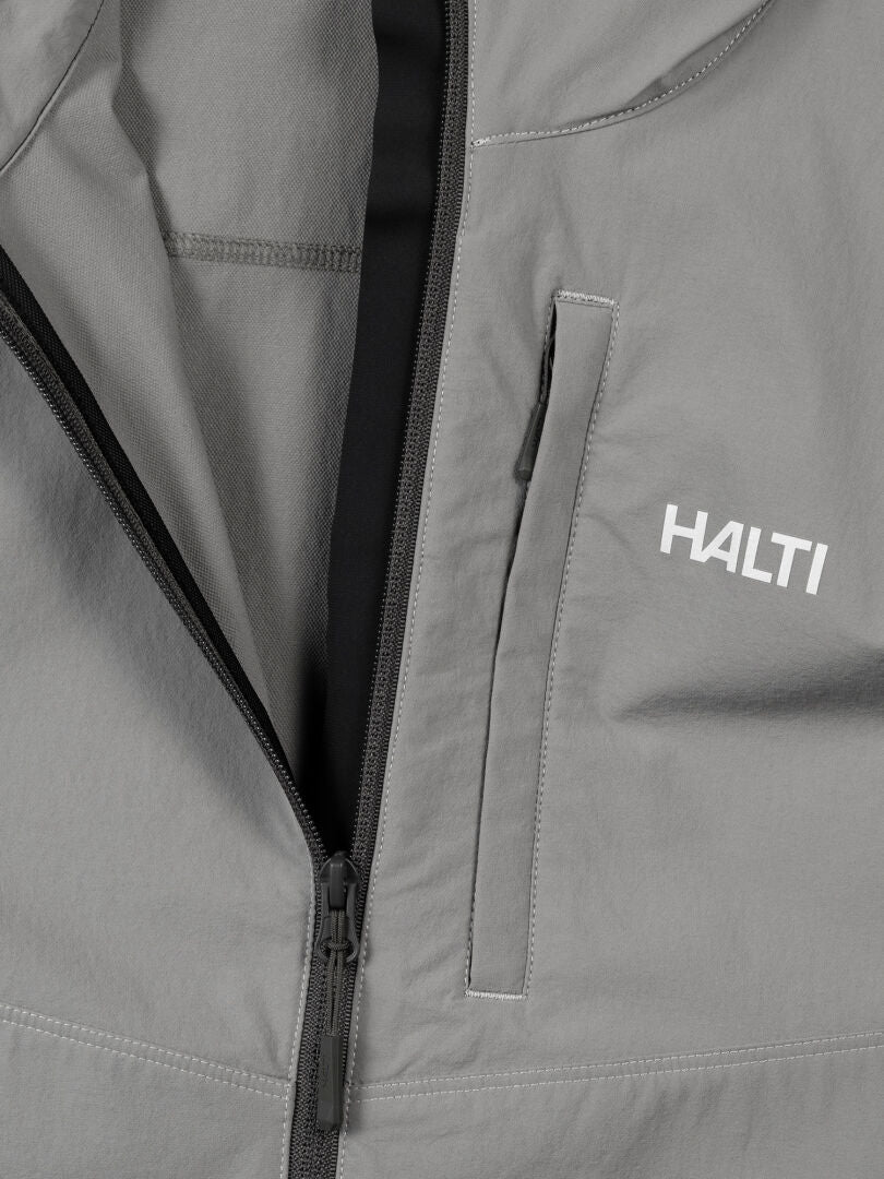 Lähikuva Halti Pallas Evo X-stretch Takki Miesten takista, jossa on näkyvä vetoketju, rintatasku ja Halti-logo edessä.