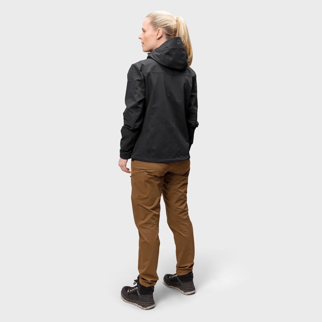 Nainen Halti Pallas Evo Harjattu X-stretch Ulkoiluhousut seisoo kasvot poispäin, valmiina vaeltamiseen.