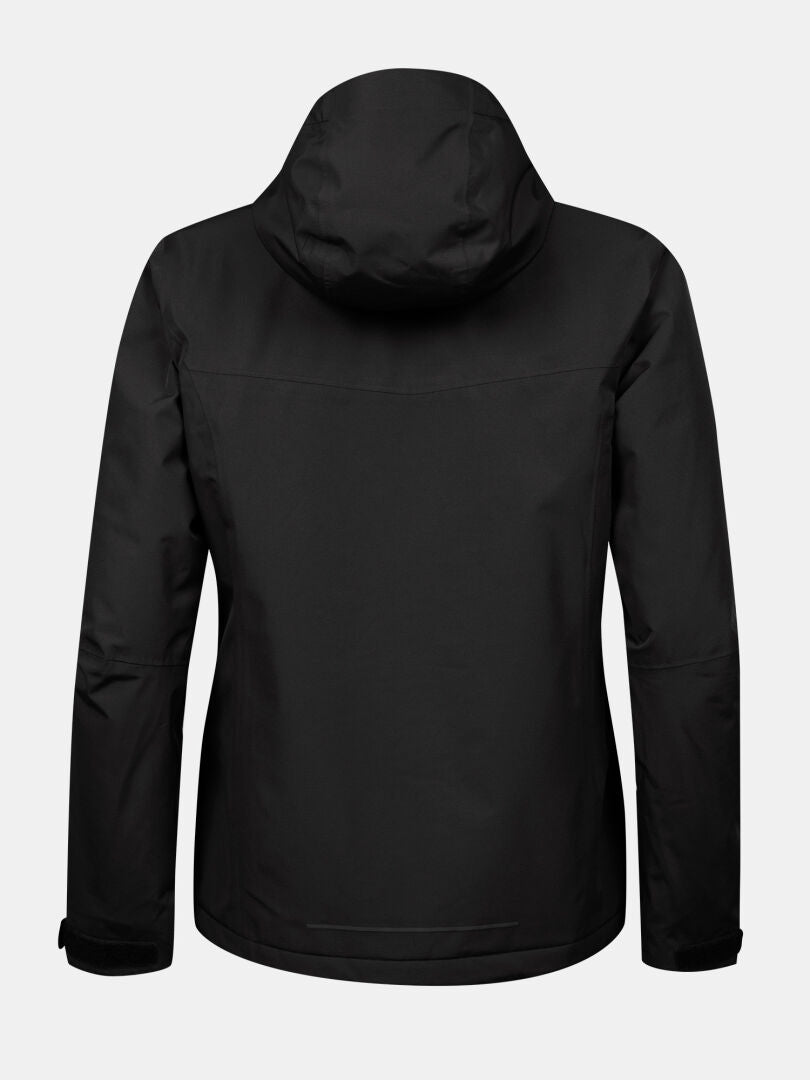 Halti Forter DX Kuoritakki Plus Naisten mustana näkyy takaa vaaleanharmaata taustaa vasten.