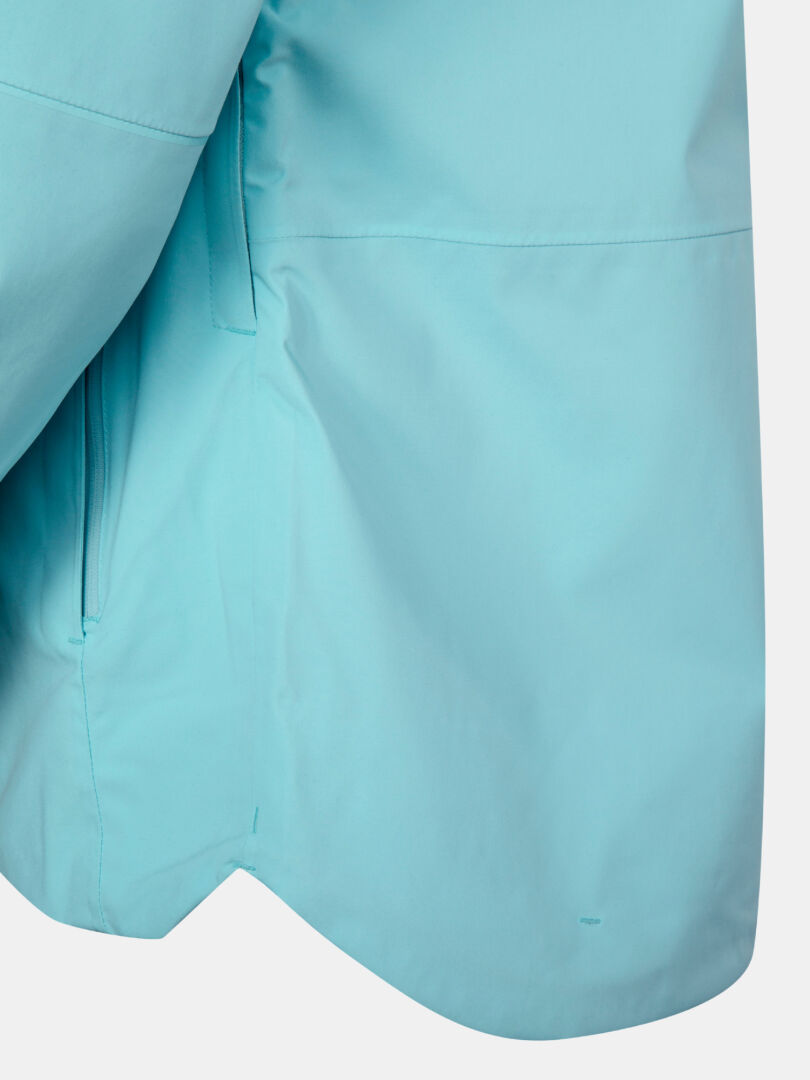 Lähikuvassa Halti Staala DX Kuoritakki Naisten vaaleansininen, jossa näkyy sivusauma ja hiha valkoisella pohjalla.