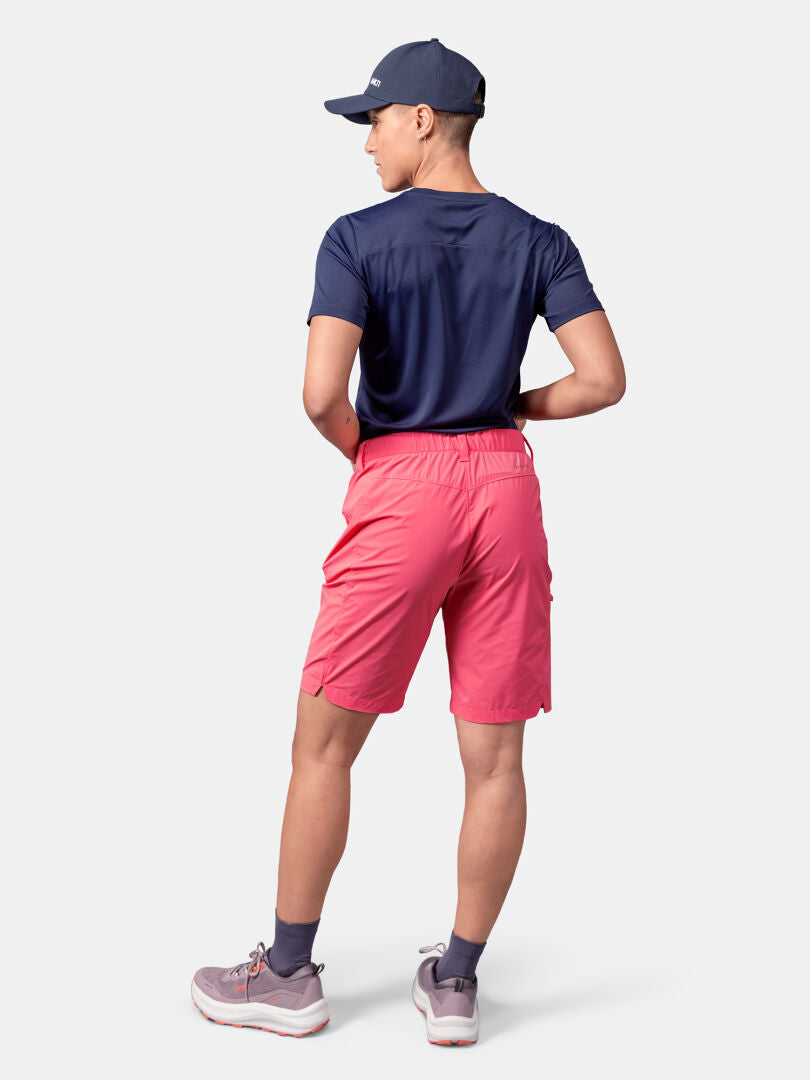 Henkilö, jolla on tummansininen t-paita ja Halti Pallas Cool Shortsit, harmaa lippis, sukat ja lenkkarit, seisoo selkä kameraan päin.