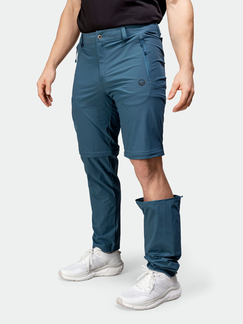 Henkilö käyttää Halti Pallas Cool Stretch Zip-off Housut Miesten toista jalkaa shortseina, mikä osoittaa niiden monipuolisuuden.