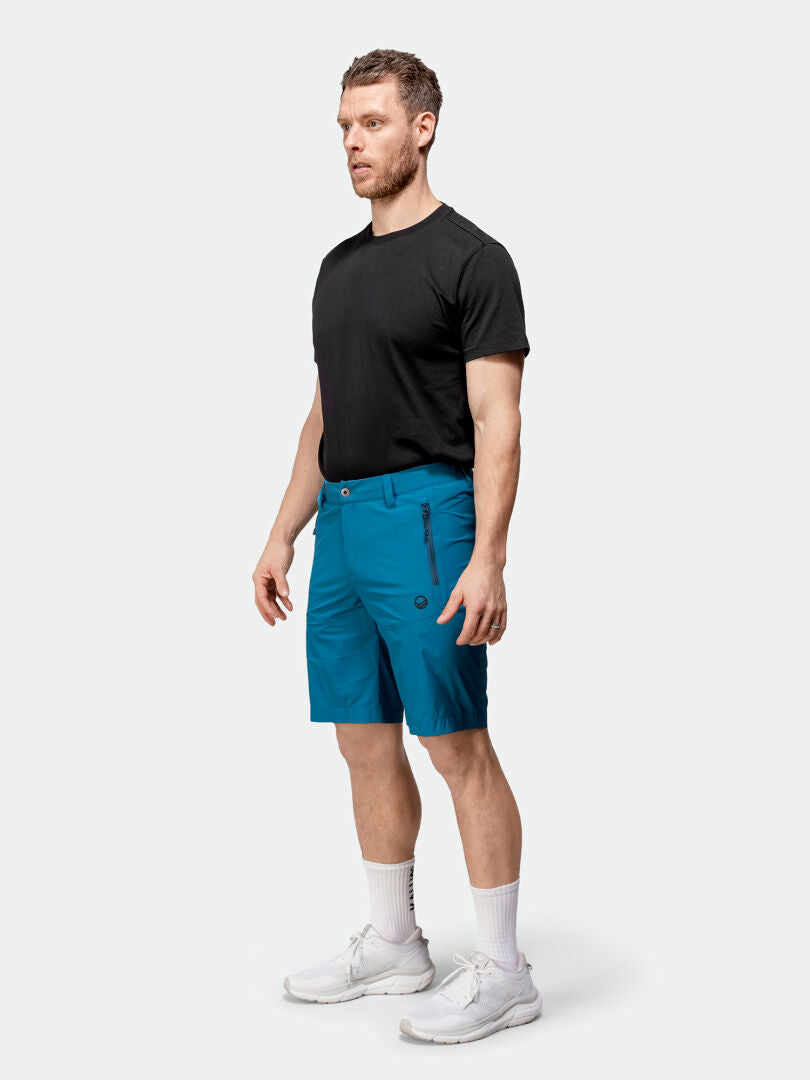 Mies katsoo eteenpäin Halti Pallas Cool X-stretch Miesten shortseissa, joissa on Dry Quick stretch ja UPF 90+ -suoja.