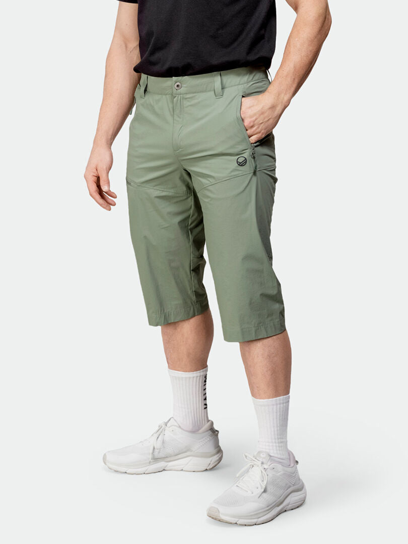 Henkilö Halti Pallas Cool X-stretch Capritissa, mustassa t-paidassa, valkoisissa sukissa ja lenkkareissa seisoo toinen käsi taskussa.