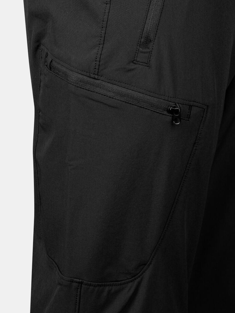 Lähikuvassa Halti Pallas X-stretch Ulkoiluhousut Miesten, jossa on diagonaalinen vetoketjullinen tasku ja näkyvät tikkaukset.