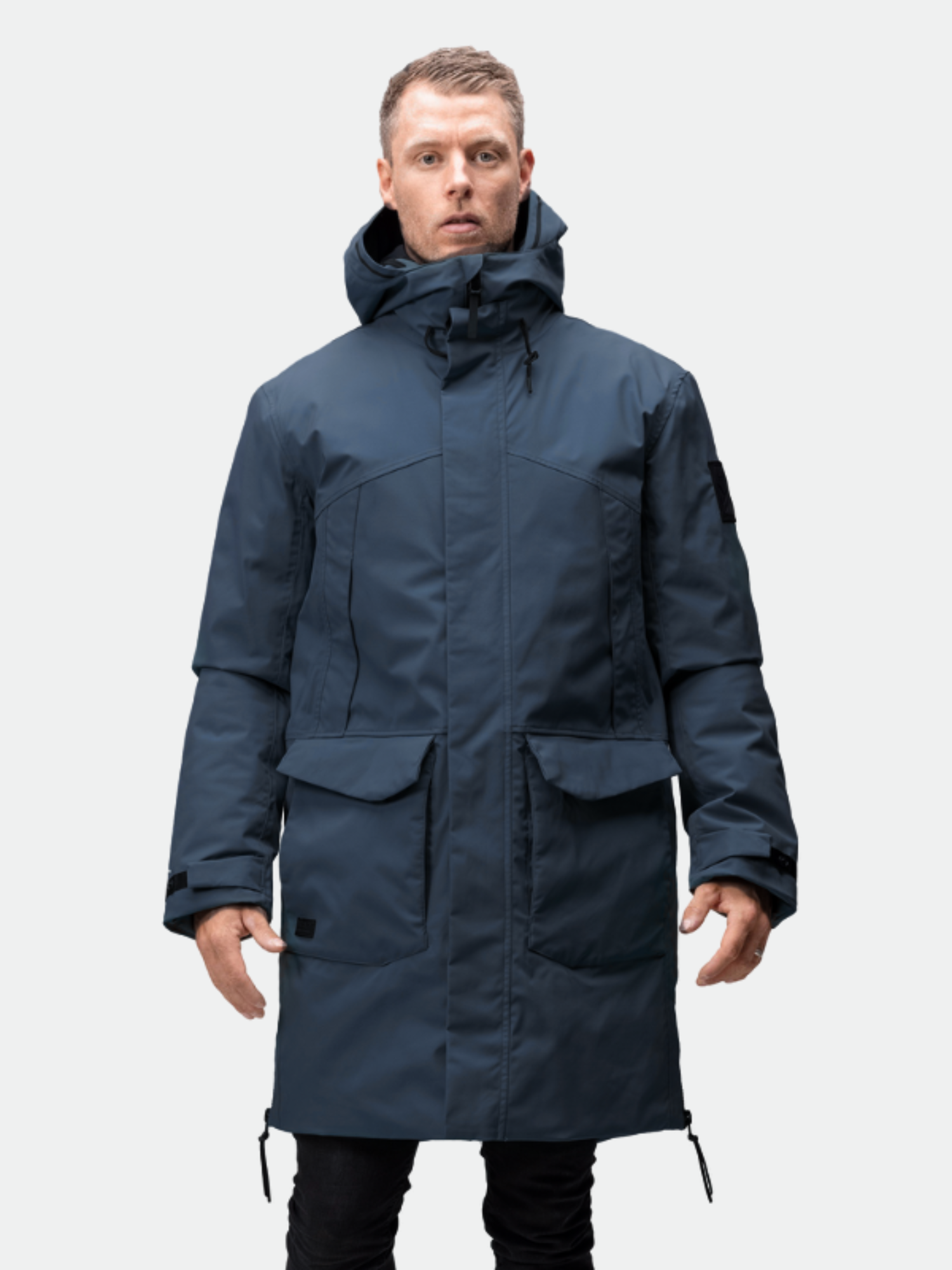 Halti Bergga DrymaxX Talvitakki Miesten mies katsoo eteenpäin vaaleanharmaata taustaa vasten.