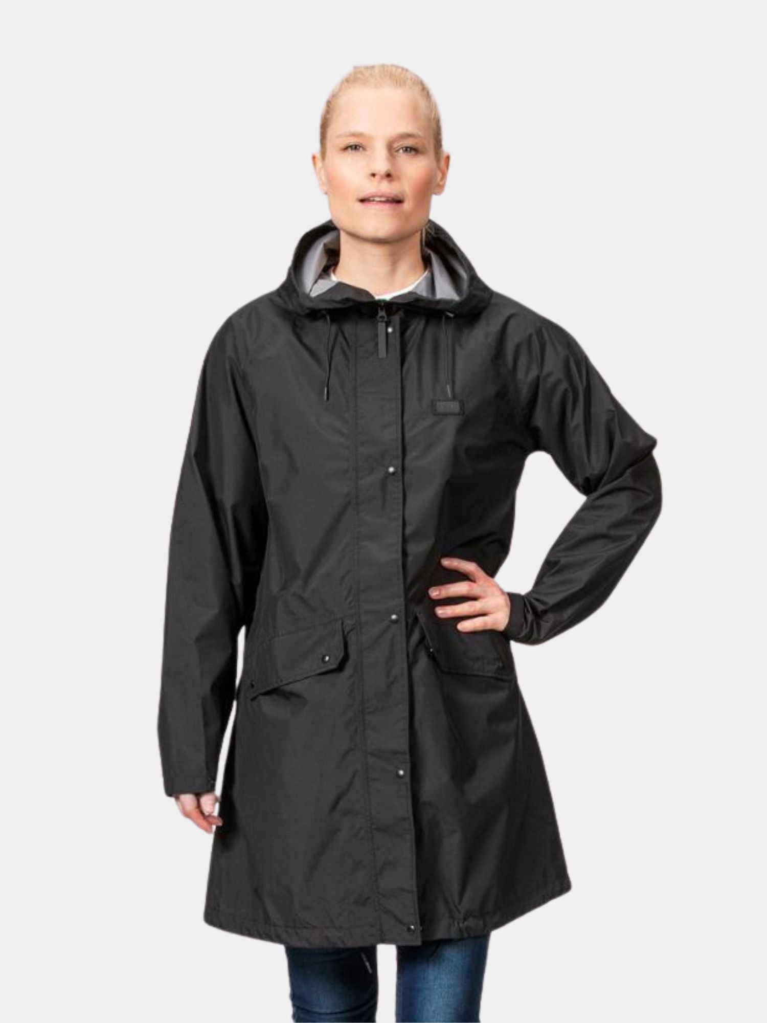 Henkilö mallinaa Halti Kevee Parkatakki Naisten -takkia toinen käsi lantiolla yksinkertaista taustaa vasten.