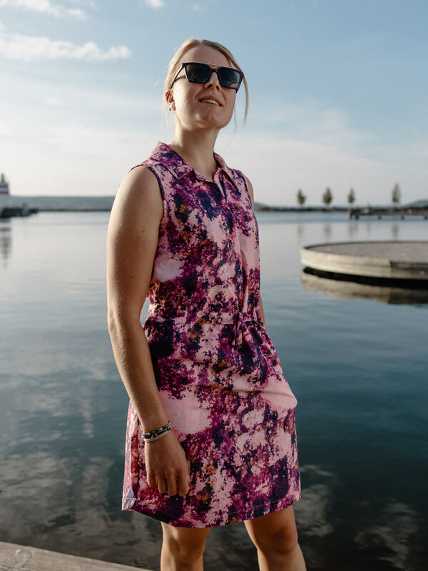 Nainen Halti Chipper X-stretch Mekko Naisten -takissa nauttii rantamaisemista aurinkoisena päivänä ja aktiivista elämäntapaa viettäen.