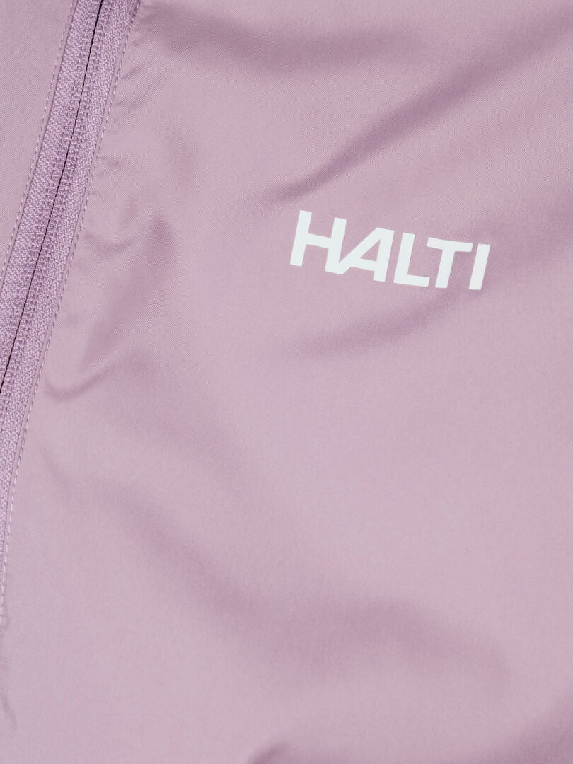 Lähikuva vaalean violetista Halti Saime Tuulitakki Naisten vetoketjusta ja valkoisesta Halti-logosta.
