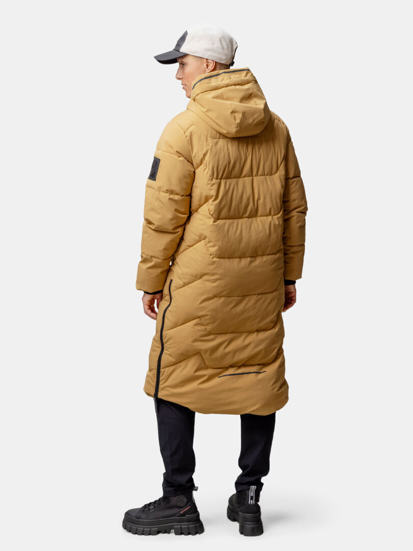 Henkilö Halti Brahe Puffer Pitkä Talvitakki Naisten, mustat housut ja harmaa lippis, takaapäin kuvattuna.