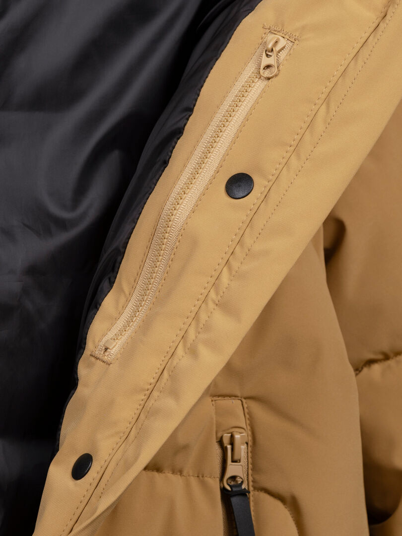 Lähikuvassa Halti Brahe Puffer Talvitakki Naisten, jossa on vetoketjullinen tasku, mustat napit ja kierrätyspolyesterivuori.