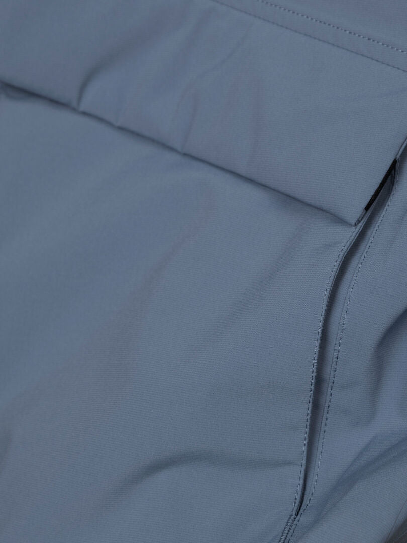 Lähikuva sinisestä Halti Kortteli DX Parka Naisten -takista, jossa näkyy läppä ja sauma, jotka todennäköisesti kuuluvat taskun yksityiskohtiin.