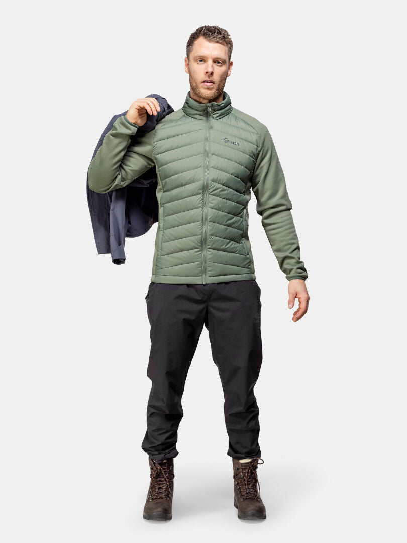 Mies pitelee Halti Huippu Hybrid Untuvatakki Miesten olkapäänsä yli tavallista taustaa vasten.