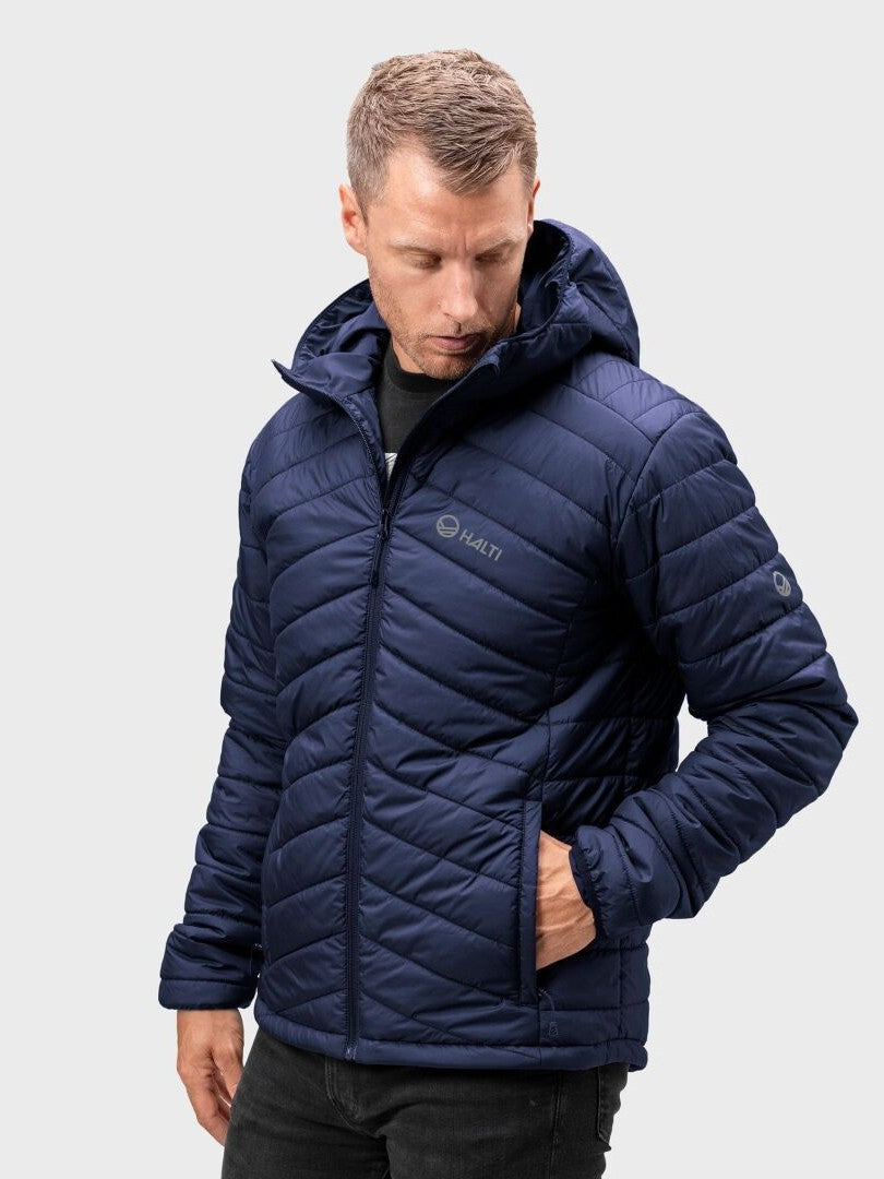 Mies yllään Halti Komu Kevytvanutakki Miesten laivastonsininen, hupullinen, kierrätyspolyesteri, katse alaspäin.