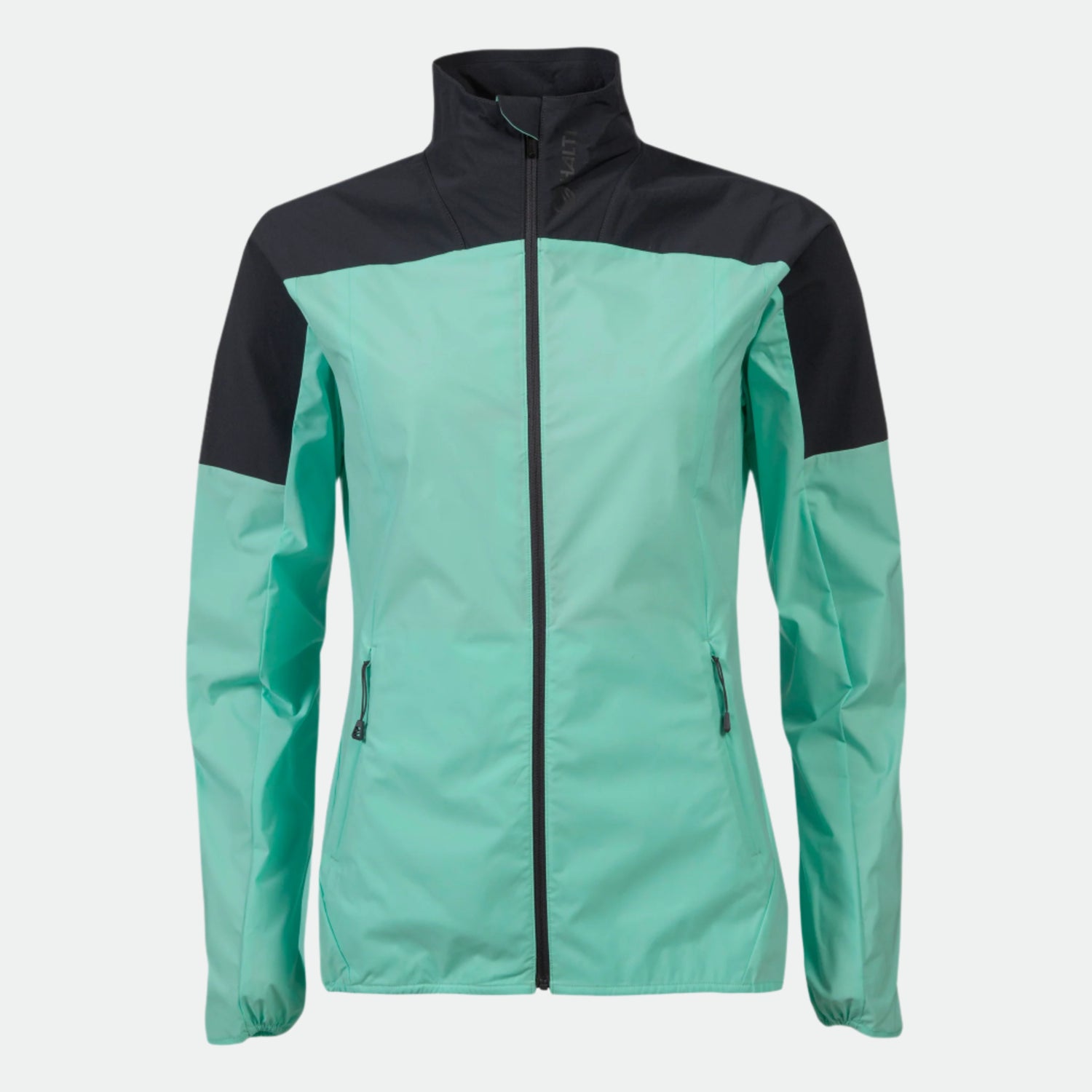 Halti Urbanite Naisten Treenitakki turkoosissa/mustassa värissä on pitkät hihat ja vetoketjutaskut yksiväristä taustaa vasten.