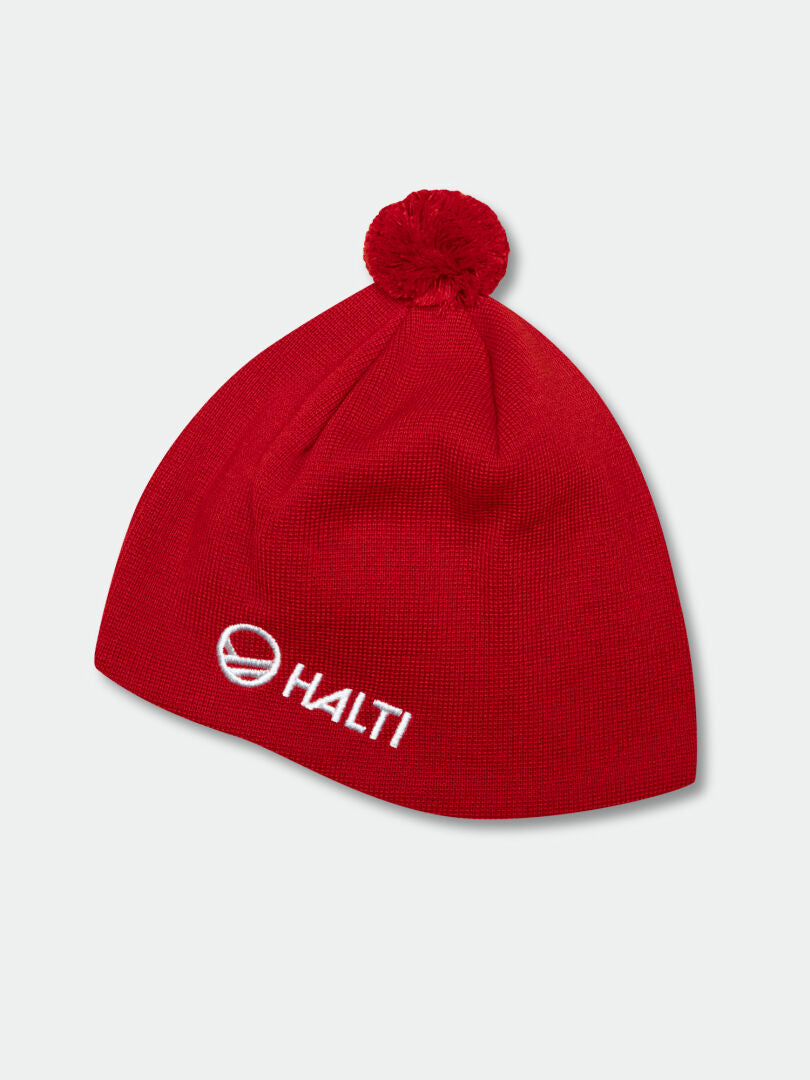 Halti Peesi Pipo on punainen merinovillapipo, jossa on tupsu ja valkoinen logo. Täydellinen maastohiihtoon.