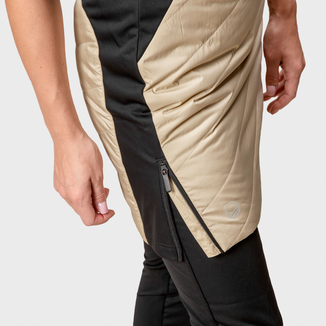 Lähikuva henkilöstä mustissa housuissa ja beigen ja mustassa Halti Hanki Toppahame Naisten – ihanteellinen treeniin tai ulkoiluun.