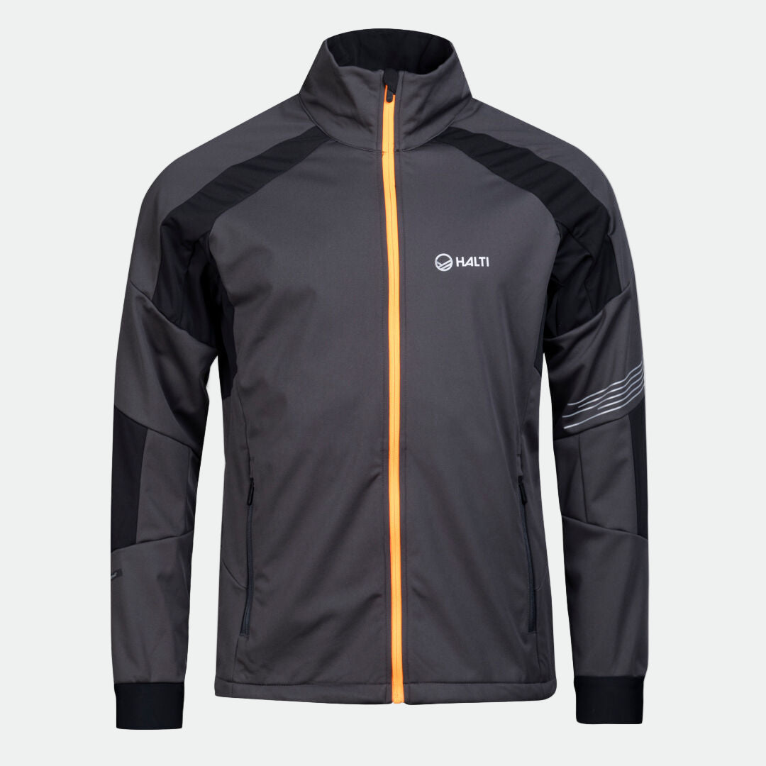 Halti Hyyde Maastohiihtopuku Miesten, harmaa softshell-puku oranssilla vetoketjulla, valkoisella pohjalla.