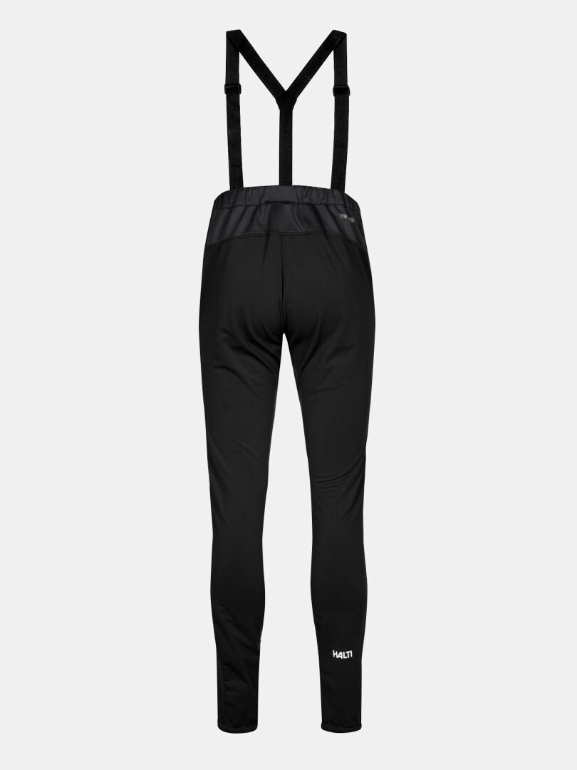 Huuru Maastohiihtopuku Naisten by Halti: mustat urheiluhousut henkseleillä, logo lähellä vasenta nilkkaa.