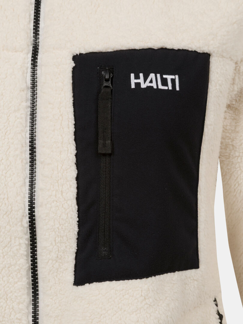 Lähikuva Halti Lumista Polar Fleecetakki Naisten vaatteesta, jossa musta rintatasku, vetoketju ja valkoinen HALTI-logo yläpuolella.