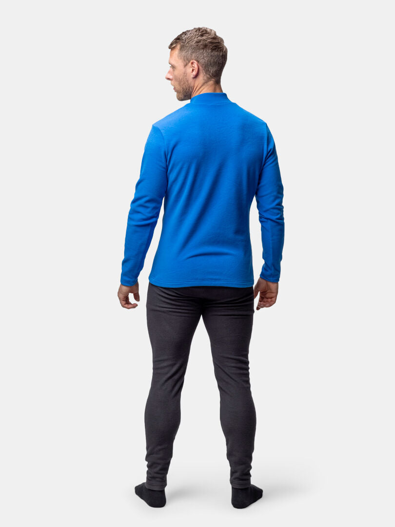 Mies kasvot poispäin, yllään Halti Trone Fleece Paita Miesten, tummat housut ja mustat sukat vaalealla pohjalla.