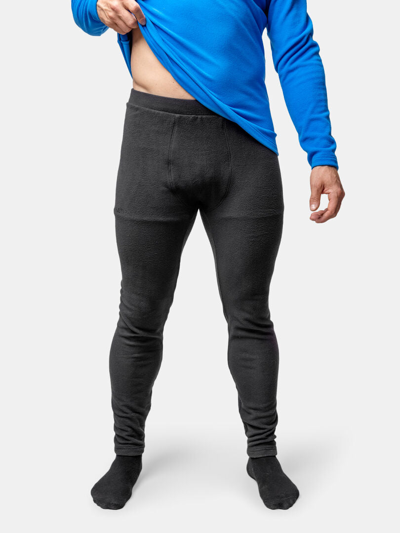 Siniseen paitaan ja mustaan Halti Trone Fleece Housut Miesten pukeutunut henkilö nostaa paitaa niin, että housujen vyötärönauha tulee näkyviin.