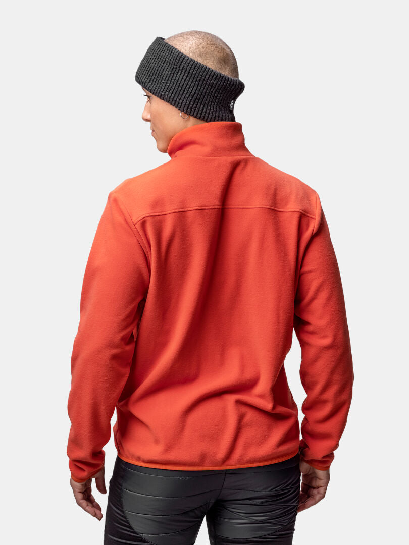 Halti Rockmoon Fleecetakki Naisten henkilö nähdään takaapäin, ulkoiluun pukeutuneena tavallista taustaa vasten.