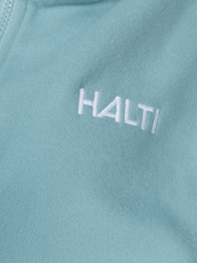 Lähikuva vaaleansinisestä Rockmoon Fleecetakki Naisten Plus by Halti, jossa on valkoisella kirjailtu HALTI.