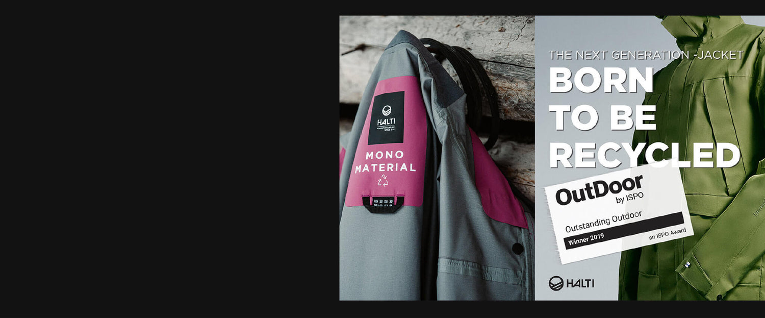 Lähikuva harmaasta ja vaaleanpunaisesta Halti-takkimerkistä, jossa lukee Mono Material vihreän takin ja kierrätysaiheisen tekstin vieressä.