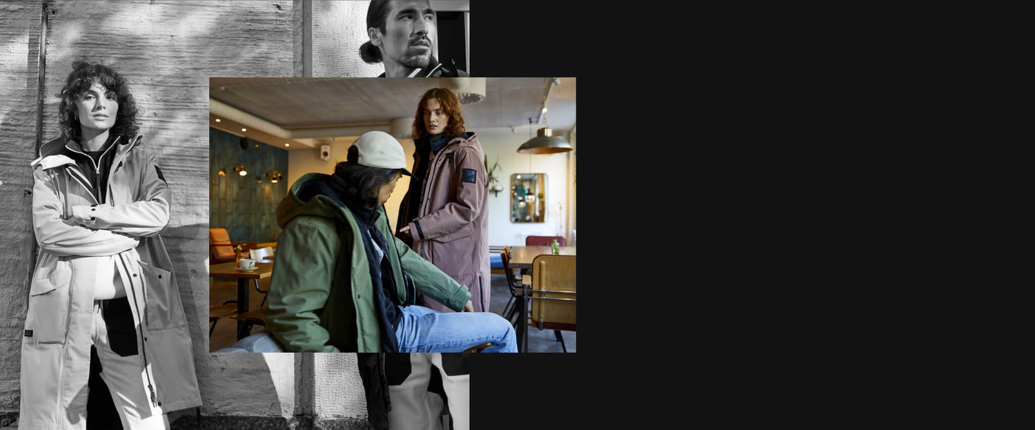 Kaksi takkiin pukeutunutta ihmistä seisoo ja istuu kahvilassa; toinen takkiin pukeutunut henkilö poseeraa ulkopuolella kädet ristissä.