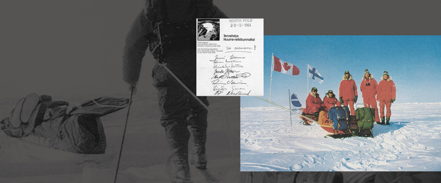 Viisi punaisiin pukuihin pukeutunutta ihmistä seisoo ja istuu lumen päällä varusteita ja lippuja sisältävien reiden vieressä, ja yläpuolella on kirje, jossa on allekirjoituksia.