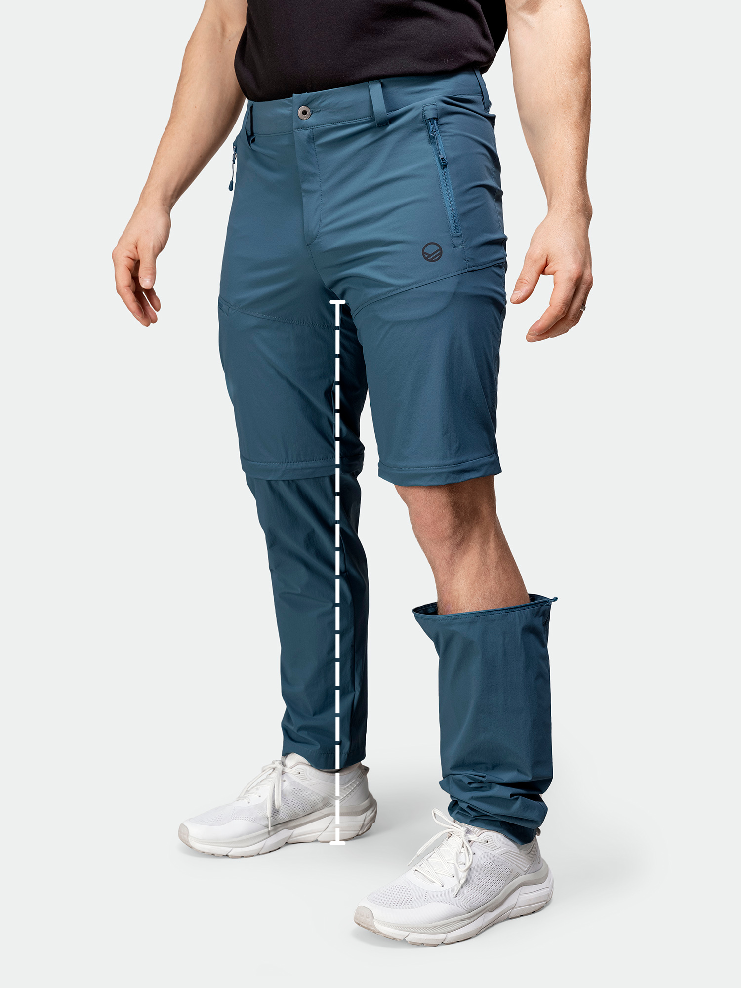 Henkilöllä on jalassaan muunneltavat siniset housut, joissa on vetoketju, toinen jalka kokonaan vetoketjulla ja toinen jalka auki, jolloin alta paljastuu shortsit.