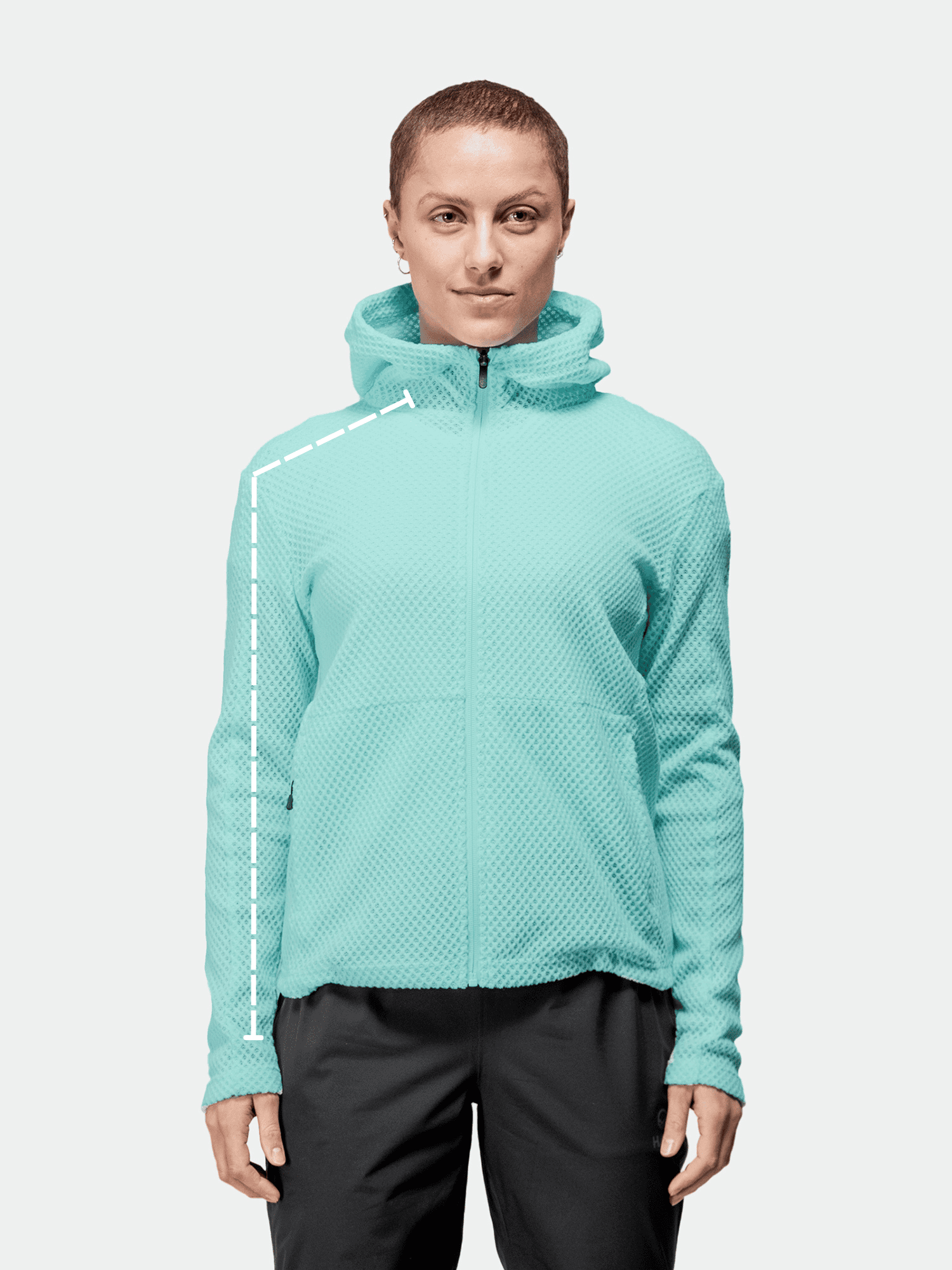 Vaaleansiniseen vetoketjulliseen huppariin ja mustiin housuihin pukeutunut henkilö seisoo kasvot menosuuntaan, ja hänen olkapäässään on katkoviiva.