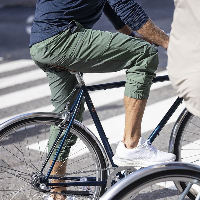 Vihreissä lenkkeilyhousuissa ja Halti Gale Lenkkari Miesten tennareissa pukeutunut henkilö ajaa polkupyörällä suojatien yli.