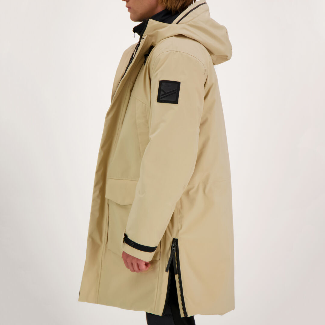 Henkilö Halti Bergga DrymaxX Talvitakki Miesten, jossa on musta käsivarren laastari, sivulta katsottuna tavallisella taustalla.