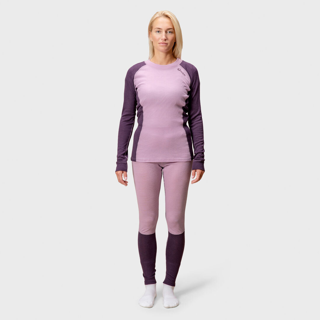 Nainen katsoo eteenpäin Halti Hossa Merinovillakerrasto Naisten, kaksivärinen violetti, jossa on yhteensopivat legginsit ja valkoiset sukat.