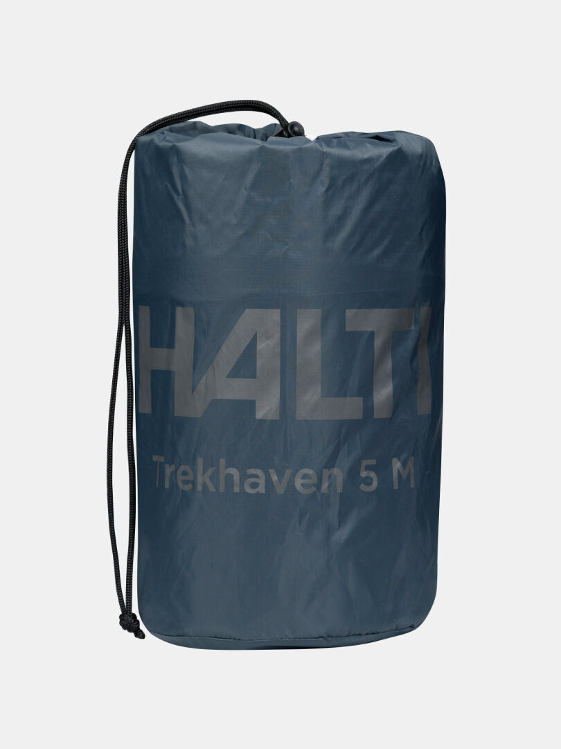 Tummansininen Halti Trekhaven 5M -makuualusta on pakattu sen kiristysnauhalliseen säilytyspussiin.