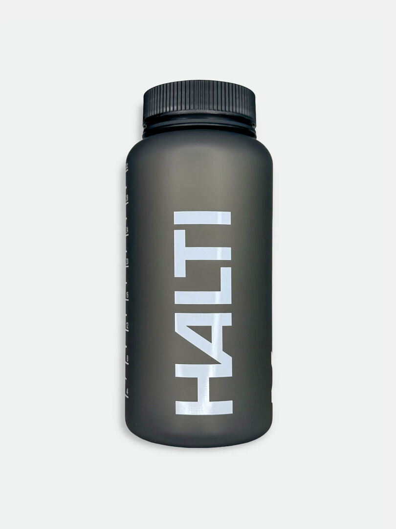 Halti Juomapullo 1 L on mattamusta PETG-pullo, jossa on musta kierrekorkki ja edessä suuret valkoiset HALTI-kirjaimet.