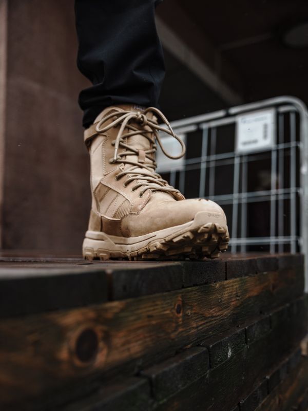 Halti Regis DX vaelluskenkä miesten seisoo märällä puupinnalla metalliaidan vieressä.