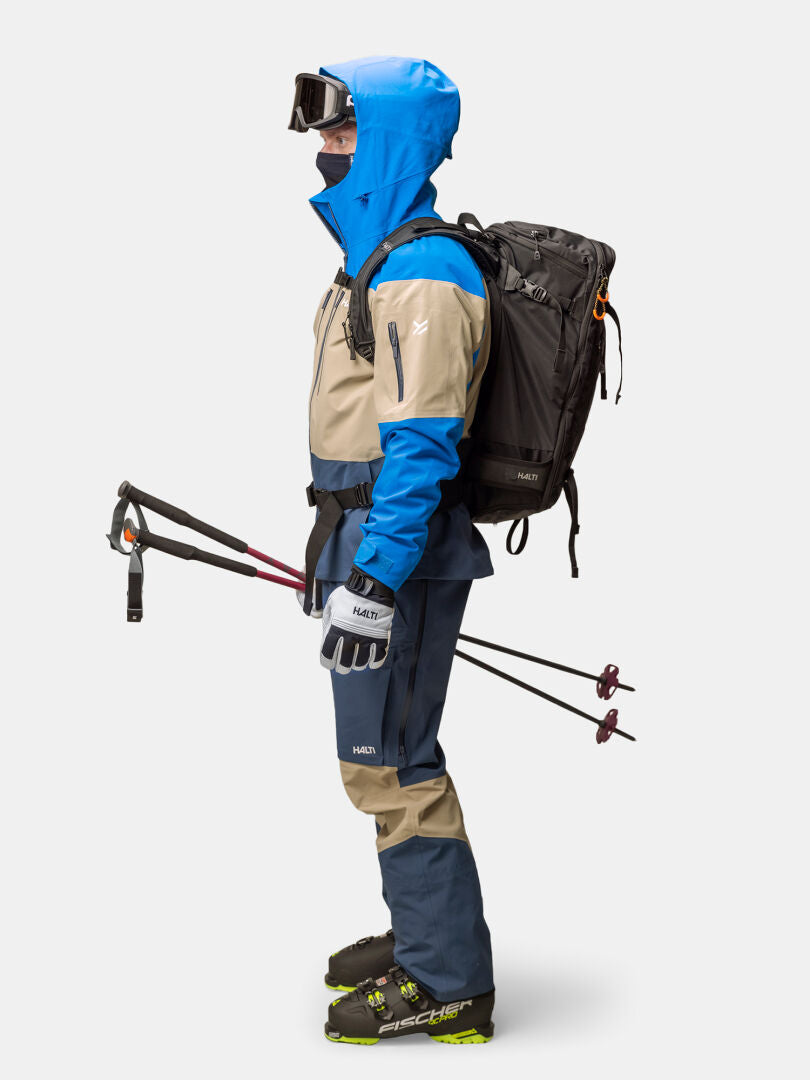 Henkilö täydessä alppihiihtovarusteessa, yllään Halti Rizle 3L DX Laskettelutakki Unisex ja Primaloft Thermo fleece.