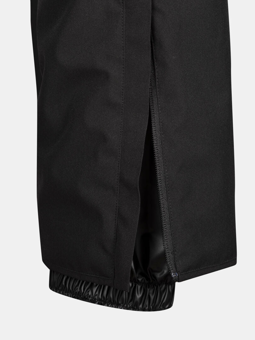 Lähikuva Halti Glades II DX naisten hiihtohousuista, musta, sivuvetoketju auki, jotta sisäinen joustava nilkkamansetti näkyy.