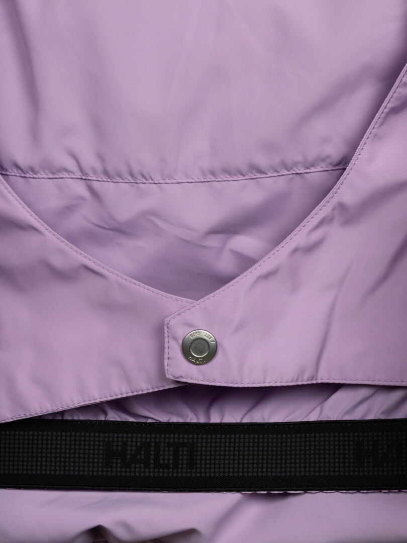 Lähikuva Halti Ascloud Puffer -laskettelutakista (naisten): vaalean violetti DrymaxX, painonappi, musta nauha, jossa teksti.